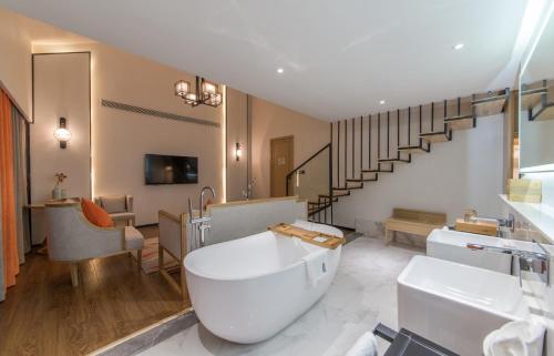 a bathroom with a tub and a sink and a staircase at Mengjing Xiyue Hotel in Kunming