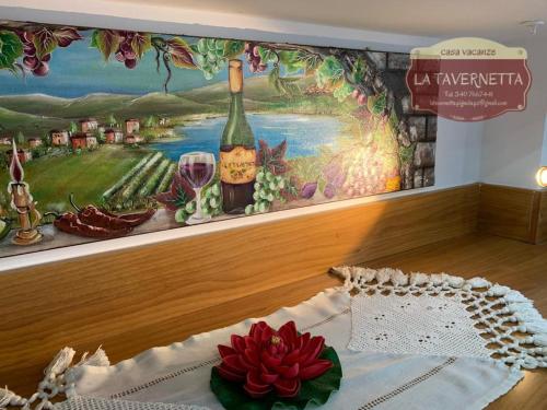 a wall with a painting of a bottle of wine at La Tavernetta in Pignola