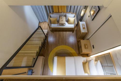 a loft bedroom with a bed and a staircase at Mengjing Xiyue Hotel in Kunming