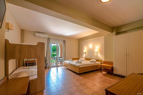 a bedroom with two beds and a large window at Castella Beach in Alissos