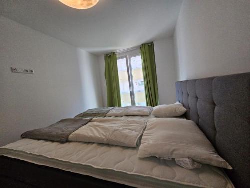 Stylish Apartment in Innsbruck + 1 parking spot في إنسبروك: سرير في غرفة نوم مع نافذة كبيرة