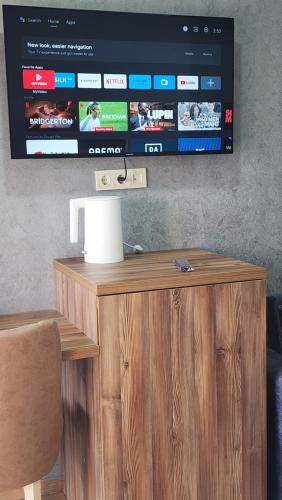 a television on top of a wooden stand with a table at Luxor Rabath in Akhaltsikhe