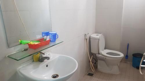 a white bathroom with a sink and a toilet at Khách sạn Hoàng Long in Ho Chi Minh City