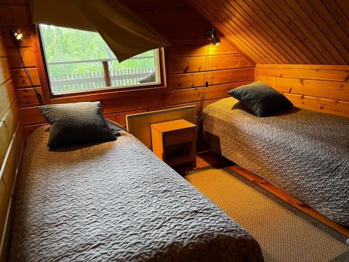 a bedroom with two beds and a window at Keskikosken Lomamökit in Venäjänjärvi