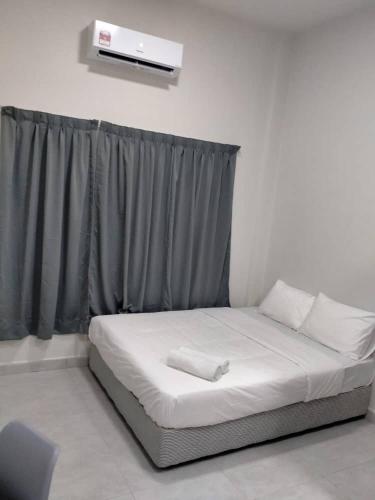 Ce lit se trouve dans un dortoir doté d'une fenêtre avec un matelas blanc. dans l'établissement Hotel Mutiara Kuala Krai, à Kuala Kerai