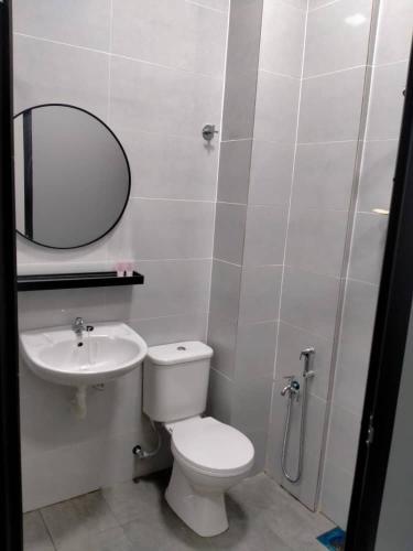 La salle de bains est pourvue de toilettes, d'un lavabo et d'un miroir. dans l'établissement Hotel Mutiara Kuala Krai, à Kuala Kerai