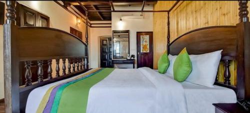 um quarto com uma grande cama branca com almofadas verdes em AVVA HOTELS em Cochin