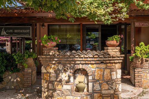 a brick fireplace in front of a store with potted plants at Castella Beach in Alissos
