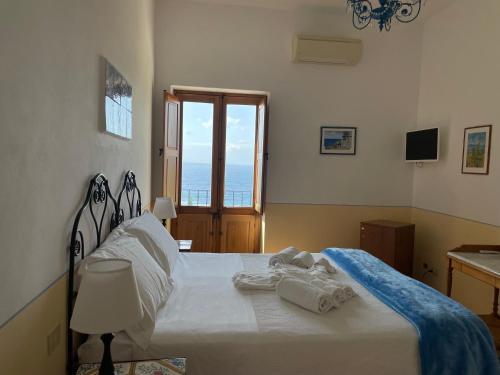 a bedroom with a bed with towels on it at Hotel La Locanda Del Postino in Pollara