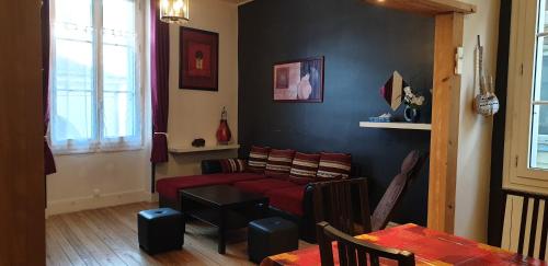 un salon avec un canapé rouge et une table dans l'établissement Bourgueil - Grand appartement proche CNPE Chinon, à Bourgueil