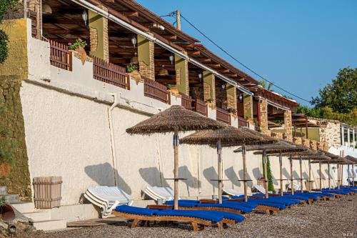 a row of beach chairs and umbrellas on a building at Castella Beach in Alissos
