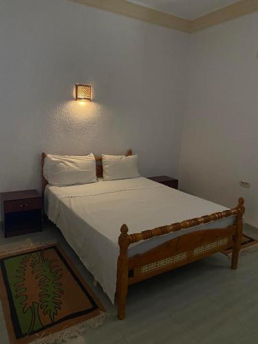 a bedroom with a bed and a light on the wall at ltifi villas aghir in Midoun