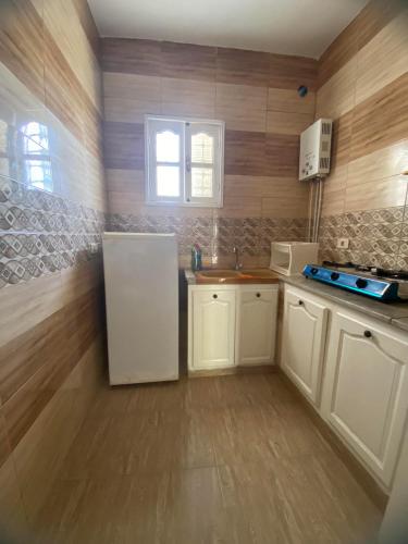 a kitchen with a white refrigerator and a sink at ltifi villas aghir in Midoun