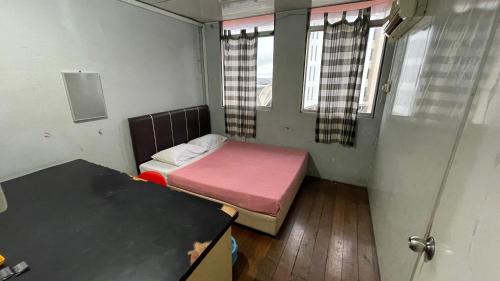 a small room with a bed and two windows at HOTEL 59 in Sibu