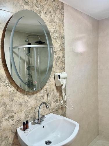 y baño con lavabo y espejo. en Twin cottages kazbegi 2 en Kazbegi