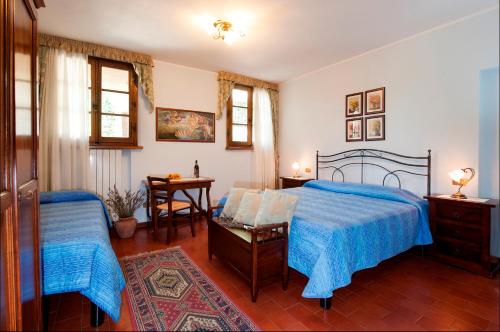 1 dormitorio con 2 camas, mesa y escritorio en B&B Casale Virgili, en Siena