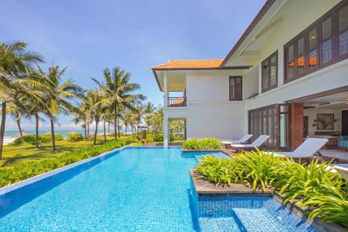 a swimming pool in front of a villa at Da Nang Beach Villas in 5-star Resort in Da Nang