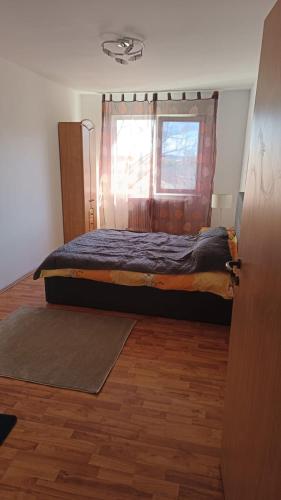 a bed in a room with a window and a door at Apartament Marly Cathedral in Gura Humorului