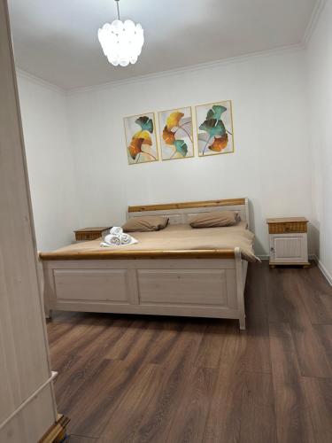 a bedroom with a bed and three pictures on the wall at Уютная квартира in Almaty