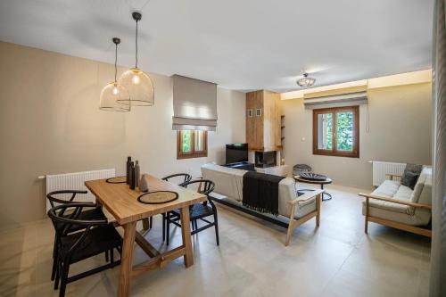 a kitchen and living room with a table and chairs at Holly Tree - Tsagarada Pelion in Tsagarada