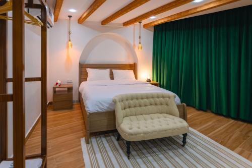 een slaapkamer met een bed en een groen gordijn bij House 76 in Nizwa