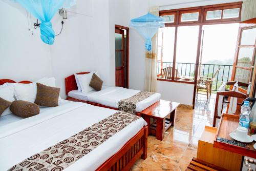 a hotel room with two beds and a balcony at Golden View Guest in Ella