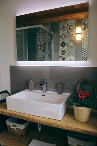 a bathroom with a white sink and a mirror at Aosta Romana case vacanza in Aosta