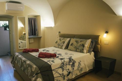 a bedroom with a bed with two red pillows on it at Aosta Romana case vacanza in Aosta
