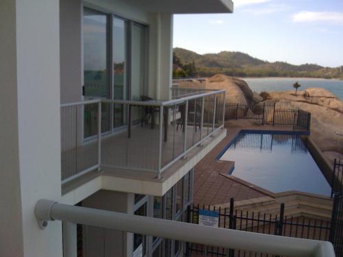 a balcony of a house with a swimming pool at Panoramic Ocean Views 2 bed/2 bath Unit, Nelly Bay in Nelly Bay