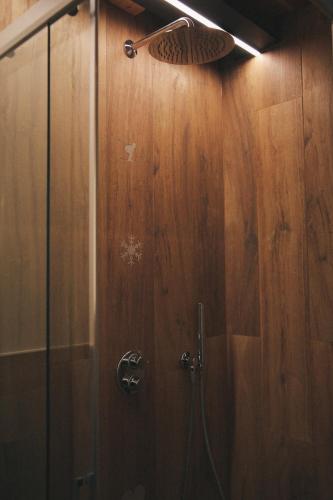 a bathroom with a shower with a wooden wall at Aosta Romana case vacanza in Aosta