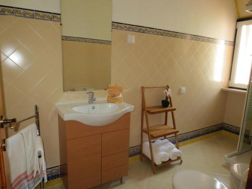 ein Bad mit einem Waschbecken und einem Spiegel in der Unterkunft Casa da Villa 1C in Sintra