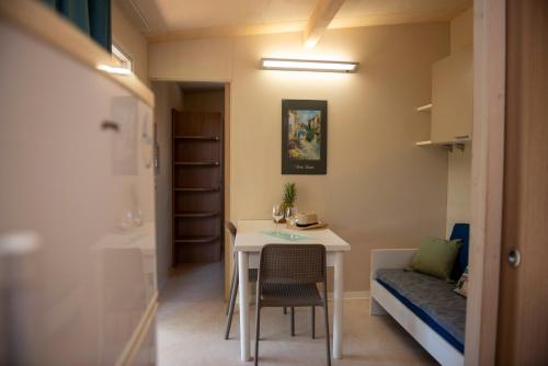 ein kleines Zimmer mit einem Tisch und einem Bett in der Unterkunft Campeggio Bocca di Cecina in Marina di Cecina