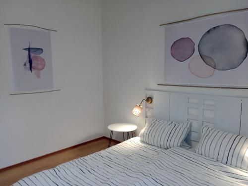 a bedroom with a white bed and a table at Pustehus Grödersby in Grödersby