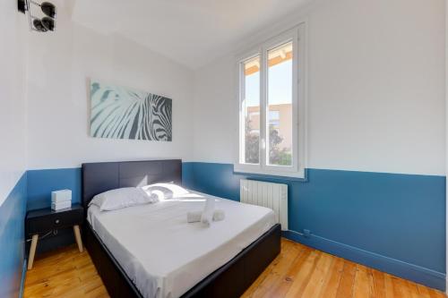 Dormitorio azul y blanco con cama y ventana en Terracotta-T2-Clim-Parking gratuit privé, en Pierre-Bénite