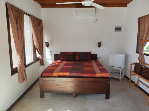 ein Schlafzimmer mit einem Bett in einem Zimmer mit Fenstern in der Unterkunft Arazo villa in Unawatuna