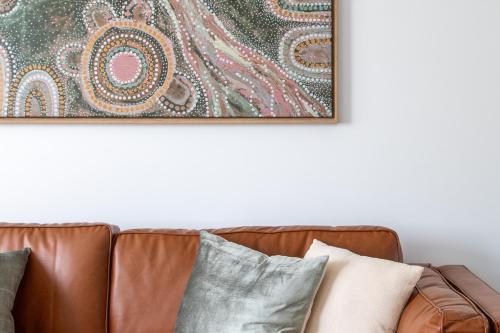 a picture hanging on a wall above a couch with pillows at The McKinlay Echuca in Echuca