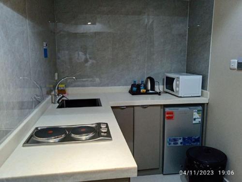 eine kleine Küche mit einer Spüle und einer Mikrowelle in der Unterkunft الماسةالتاج للشقق الفندقية in Ha'il