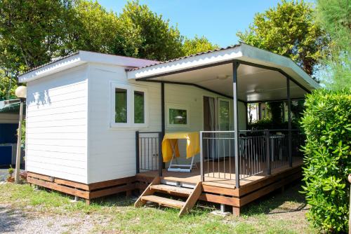 a tiny house with a porch and a deck at Campeggio Bocca di Cecina in Marina di Cecina