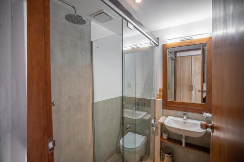 a bathroom with a sink and a toilet and a mirror at Hotel Onrock in Ella