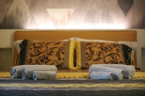 a bed with three towels sitting on top of it at Aosta Romana case vacanza in Aosta