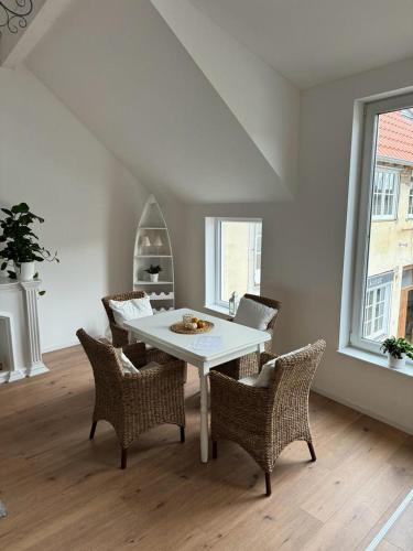 uma sala de jantar com uma mesa branca e cadeiras em Ferienwohnung Im Heuspeicher em Meckenheim