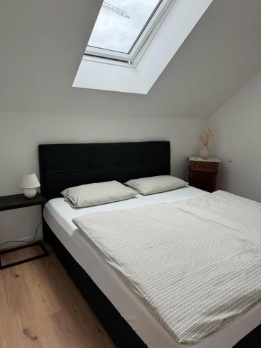 um quarto com uma cama grande e uma clarabóia em Ferienwohnung Im Heuspeicher em Meckenheim