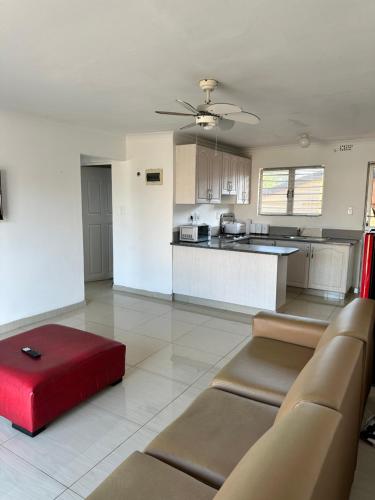 a living room with a couch and a red ottoman at Wood Road Apartments in Durban