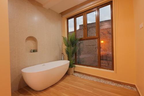 uma casa de banho com uma banheira branca e uma janela em House 76 em Nizwa