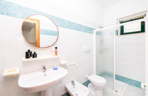 a bathroom with a sink toilet and a mirror at Baia Degli Aranci Suite & Apartments in Vieste