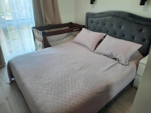 - un lit avec 2 oreillers dans une chambre dans l'établissement Romos apartamentai Klaipėdoje, à Klaipėda
