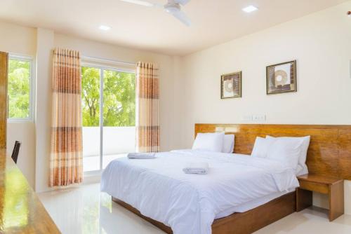 a bedroom with a large bed and a window at MEHEL - Holiday Home - Mahibadhoo in Mahibadhoo