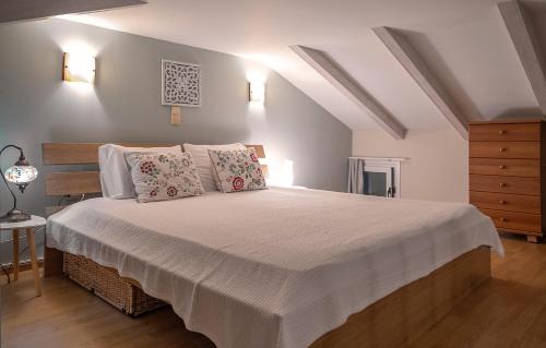 sypialnia z dużym łóżkiem z białą pościelą i poduszkami w obiekcie Sunset Riza w Prewezie