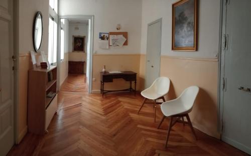 a hallway with two white chairs and a desk at Hostal Yolanda in Madrid