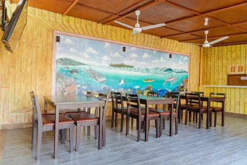 un comedor con una gran pintura en la pared en MEHEL - Holiday Home - Mahibadhoo en Mahibadhoo